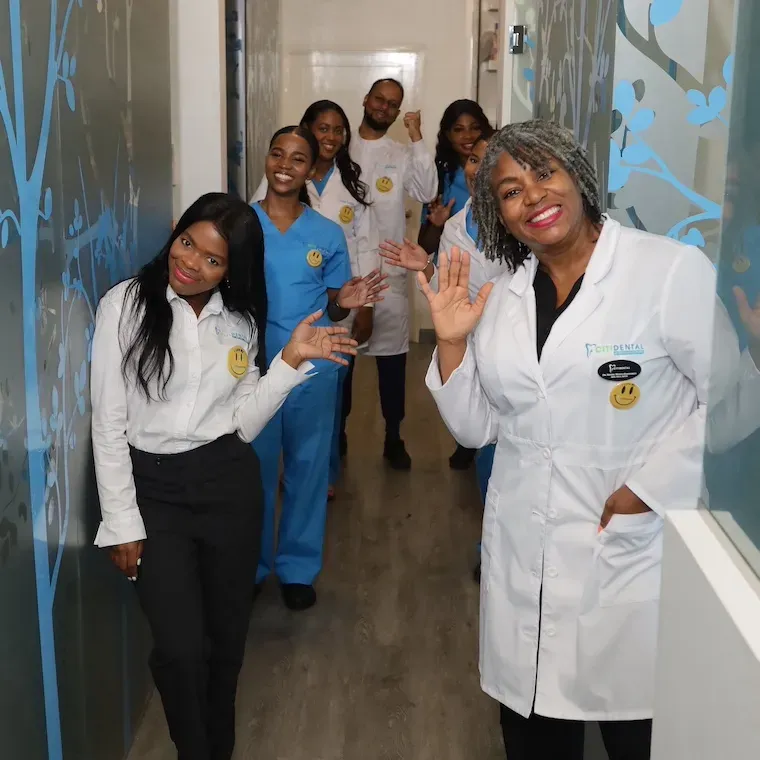 The Citidental team smiling and waving in the office hallway